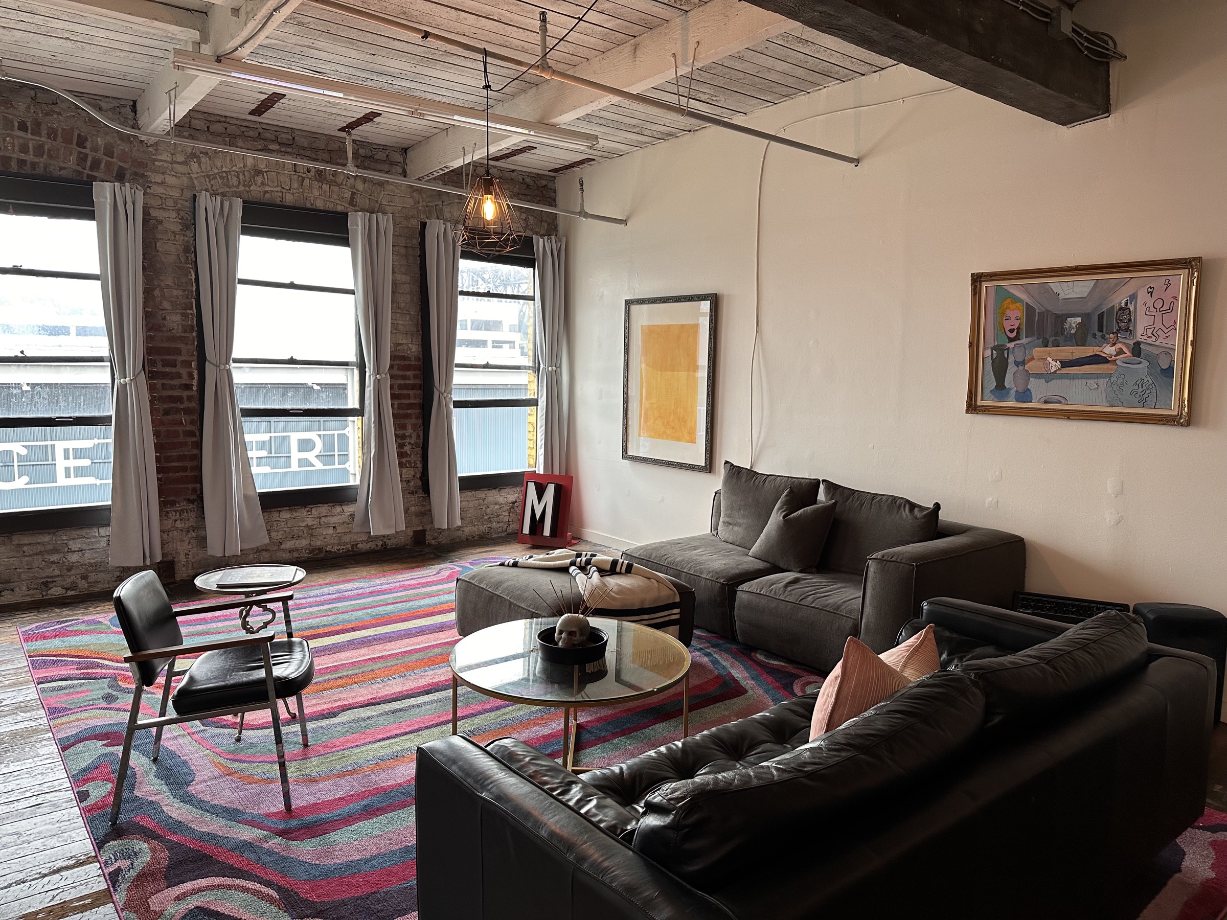 Lounge corner with sofas, a colorful rug and art on the walls