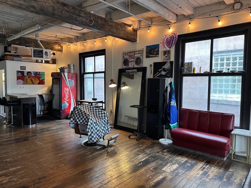Barber chair, standing mirror and a red couch by the windows